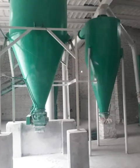 Two teal cyclone separators in a processing shed.