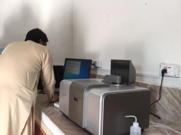 Technician using an analytical instrument and computer in the laboratory.